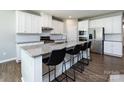 Stylish kitchen island featuring granite countertops, barstool seating, and stainless appliances at 2018 Sewall Sw Ave, Concord, NC 28025