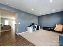 Spacious living room featuring a modern desk setup and a comfortable armchair at 2018 Sewall Sw Ave, Concord, NC 28025