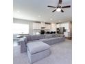 Open-concept living room and kitchen with a large gray sectional couch and breakfast bar at 2018 Sewall Sw Ave, Concord, NC 28025
