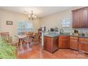 Well-lit kitchen and dining area featuring wooden floors, granite counters, stainless dishwasher, and ample cabinet space at 2408 Joes Lake Rd, Shelby, NC 28152