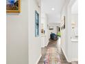 Inviting hallway with hardwood floors, decorative wall art, and an open view into the living area at 3224 Selwyn Farms Ln # 3, Charlotte, NC 28209