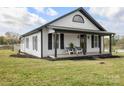 Charming home featuring a covered porch with chairs, black shutters, and a well-maintained front yard at 382 Cole Campbell Rd, Taylorsville, NC 28681
