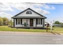 Inviting home featuring a covered porch with chairs, black shutters, and a well-maintained front yard at 382 Cole Campbell Rd, Taylorsville, NC 28681