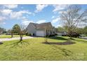 Well-maintained home featuring a spacious lawn, mature trees, and an attached two-car garage at 408 Harvest Ter, Clover, SC 29710