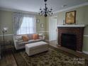 Inviting living room with a decorative chandelier, a classic fireplace, and comfortable seating at 526 Arlington Ave, Albemarle, NC 28001