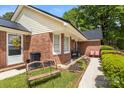 Brick home featuring an outdoor bench, rocking chairs, and a well-kept garden area at 5762 Hightower Rd, Fort Lawn, SC 29714