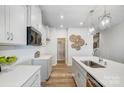 Modern kitchen features white cabinets, stainless appliances, quartz countertops, walk-in pantry, and wood floors at 6427 Mallow Crossing Ln, Charlotte, NC 28213