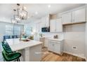 Modern kitchen features white cabinets, stainless appliances, quartz countertops, an island with seating, and wood floors at 6427 Mallow Crossing Ln, Charlotte, NC 28213