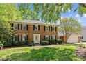 Inviting two-story brick home with black shutters, manicured lawn, and attached garage at 9607 Stoney Hill Ln, Charlotte, NC 28277
