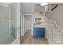 Bright foyer with a stylish blue cabinet, staircase, and wood-look flooring at 9607 Stoney Hill Ln, Charlotte, NC 28277