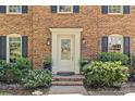 Close-up of the home's front door, flanked by potted plants and classic black shutters at 9607 Stoney Hill Ln, Charlotte, NC 28277