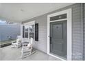 Inviting covered front porch featuring rocking chairs and a view of the home's manicured lawn at 1018 Hinson Forest Rd, Monroe, NC 28110