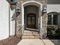 Elegant home entrance featuring brick steps, stone accents, and stylish lanterns creating a welcoming ambiance at 11447 Egrets Point Dr, Charlotte, NC 28278