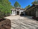 Beautiful home featuring stone accents, a large driveway, and a prominent three-car garage at 11447 Egrets Point Dr, Charlotte, NC 28278