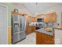 Spacious kitchen with stainless steel appliances, granite countertops, and wooden cabinets at 117 Heath Ln, Mooresville, NC 28117
