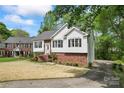Charming home with a brick and vinyl exterior, black shutters and landscaped front yard and paved driveway at 12822 Diamond Dr, Pineville, NC 28134