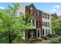 Exterior of a two-story brick townhome featuring neat landscaping and black shutters at 12905 Bullock Greenway Blvd, Charlotte, NC 28277