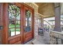 Charming front porch with a wood ceiling, rocking chairs, and decorative wreaths on the glass front doors at 141 Forsythia Ln, Tega Cay, SC 29708
