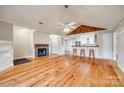Spacious living room with hardwood floors, fireplace, fan, and breakfast bar looking into the kitchen at 1545 Wimbleton Woods Dr, Fort Mill, SC 29708