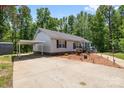 Inviting ranch with carport features manicured landscaping, beautiful flowerbed, and an expansive concrete driveway at 1756 Martin Rd, Kings Mountain, NC 28086