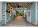 Cozy covered back porch with ceiling fan, mounted TV, and stylish outdoor furniture at 1801 Wilmore Dr, Charlotte, NC 28203