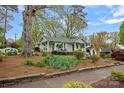 Charming single-story home with light blue siding, a welcoming front porch, and mature landscaping at 1801 Wilmore Dr, Charlotte, NC 28203