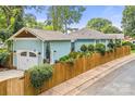 Charming light blue home features a garage and privacy fence, complemented by lush landscaping at 1801 Wilmore Dr, Charlotte, NC 28203
