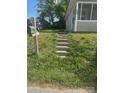 Green mailbox stands near concrete steps ascending to a quaint home at 211 W 2Nd St, Kershaw, SC 29067