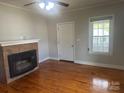 Living room features hardwood floors, brick fireplace, and natural light at 211 W 2Nd St, Kershaw, SC 29067