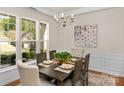 Bright dining room with wainscoting, a decorative chandelier, and large windows at 2136 Ashley River Rd, Waxhaw, NC 28173