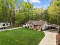Aerial view of a charming single-story home surrounded by lush trees and a well-manicured lawn at 214 Creek View Rd, Mooresville, NC 28117