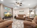 Cozy living room with neutral walls, ceiling fan, plush furniture, and a large television at 2234 Emerald Mine Rd, Shelby, NC 28152