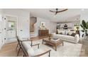 Bright living room featuring light wood floors, modern furnishings, and an open floor plan leading to the kitchen at 2512 Remington St, Charlotte, NC 28216