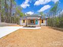 Charming single-story home featuring a light gray exterior, vibrant blue front door, and lovely landscaping at 297 Barr Link Rd, Mount Pleasant, NC 28124