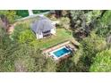 Aerial view showing a house surrounded by trees with a fenced in pool area and screened in porch at 3207 Oak Ridge Cir, Lincolnton, NC 28092