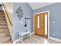 Inviting foyer with a staircase, a wooden-doored entryway, light blue walls, and a decorative wall piece at 365 Kinder Rd, Harmony, NC 28634