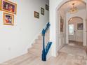 Bright foyer with hardwood floors, staircase with blue railing, arched doorway and elegant lighting at 4024 Whipcord Dr, Waxhaw, NC 28173