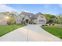 Charming two-story home with stone and siding, a manicured lawn, and an extended driveway at 4025 Foxes Trl, Cramerton, NC 28032