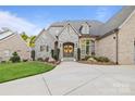 Elegant stone and brick home with a welcoming front entrance and well-manicured lawn at 4025 Foxes Trl, Cramerton, NC 28032