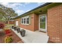 Inviting front porch with red brick, decorative plants and a 'home sweet home' welcome mat at 424 Mirror Lake Rd, Salisbury, NC 28146