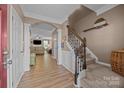 Elegant foyer featuring hardwood floors, staircase with wooden banister, and an arched entryway to the living area at 428 Winecoff Woods Nw Dr, Concord, NC 28027