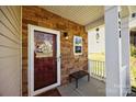 Inviting front porch with stone accents, a cozy bench, and stylish decor, perfect for relaxing at 428 Winecoff Woods Nw Dr, Concord, NC 28027