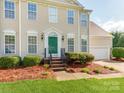 Inviting front exterior with a green front door, detailed trim, and a manicured landscape with shrubs and pine straw at 431 Harvest Ter, Lake Wylie, SC 29710