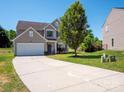 Traditional two-story home with a long driveway, attached garage, and well-manicured front lawn at 5102 Candleglow Ct, Indian Trail, NC 28079