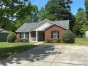 An attractive single-story brick home with a driveway and landscaped front yard at 6239 Burmith Ave, Charlotte, NC 28269