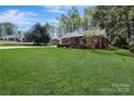This beautiful brick house features lush green grass, a manicured lawn, and a welcoming front entrance at 6549 Wesbrook Dr, Charlotte, NC 28214