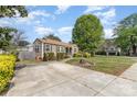 A well-kept home with a spacious front yard, mature tree, and ample parking on a concrete driveway at 665 Melbourne Ct, Charlotte, NC 28209