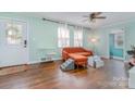 Cozy living room featuring hardwood floors, bright windows, and neutral paint, with a modern orange sofa at 665 Melbourne Ct, Charlotte, NC 28209
