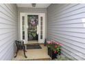 Welcoming front porch with a decorative wreath, flowers, and a charming bench at 7515 Shadowstone Dr, Charlotte, NC 28270