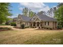Beautiful brick home featuring mature landscaping, a covered porch, and classic architectural details at 7982 Buena Vista Dr, Denver, NC 28037